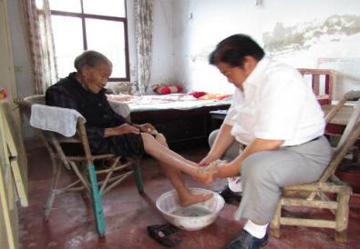 上图：给慈母洗脚