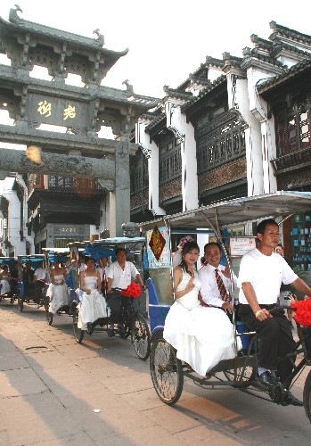 10月5日，新人们乘坐三轮车游览屯溪老街。