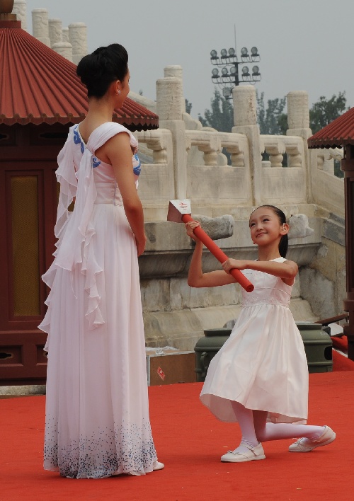 单腿跪地将点火棒递给姜馨田的小姑娘汪伊美用灿烂的笑脸感动了世界