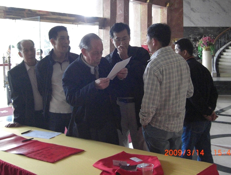 与会本家在报到处就开始交流讨论