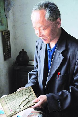 5月27日，汪金权在自己简陋的宿舍里看书。新华社记者皮曙初摄