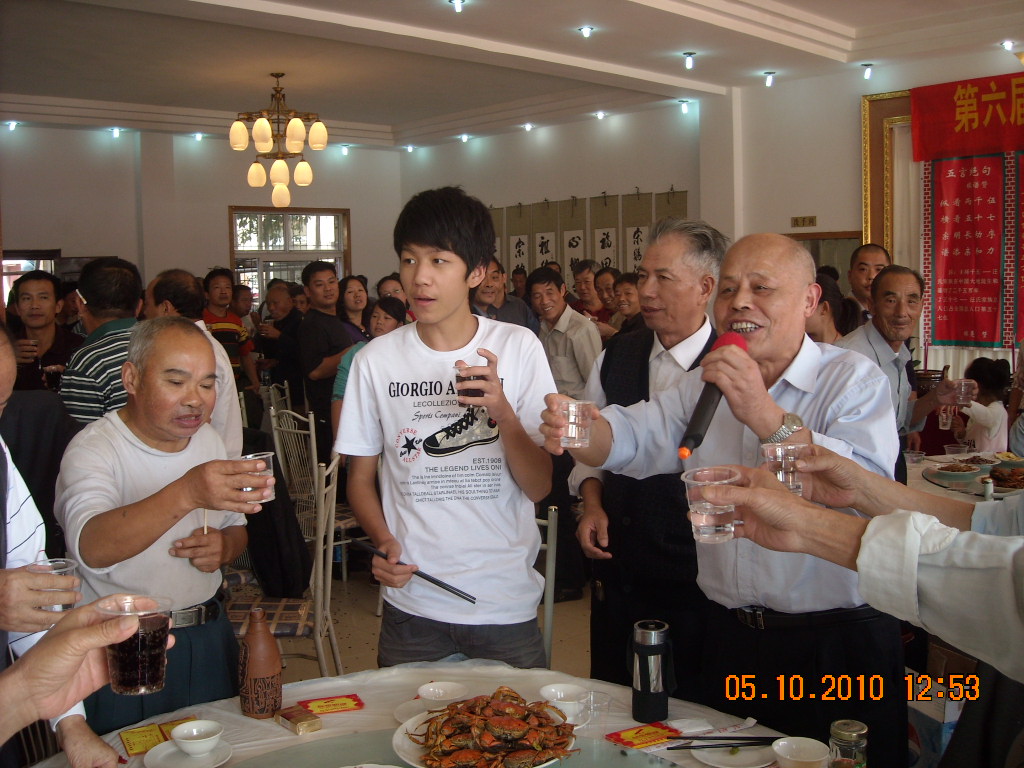 振阳会长高举酒杯让大家吃好喝好，为汪氏一家亲干杯