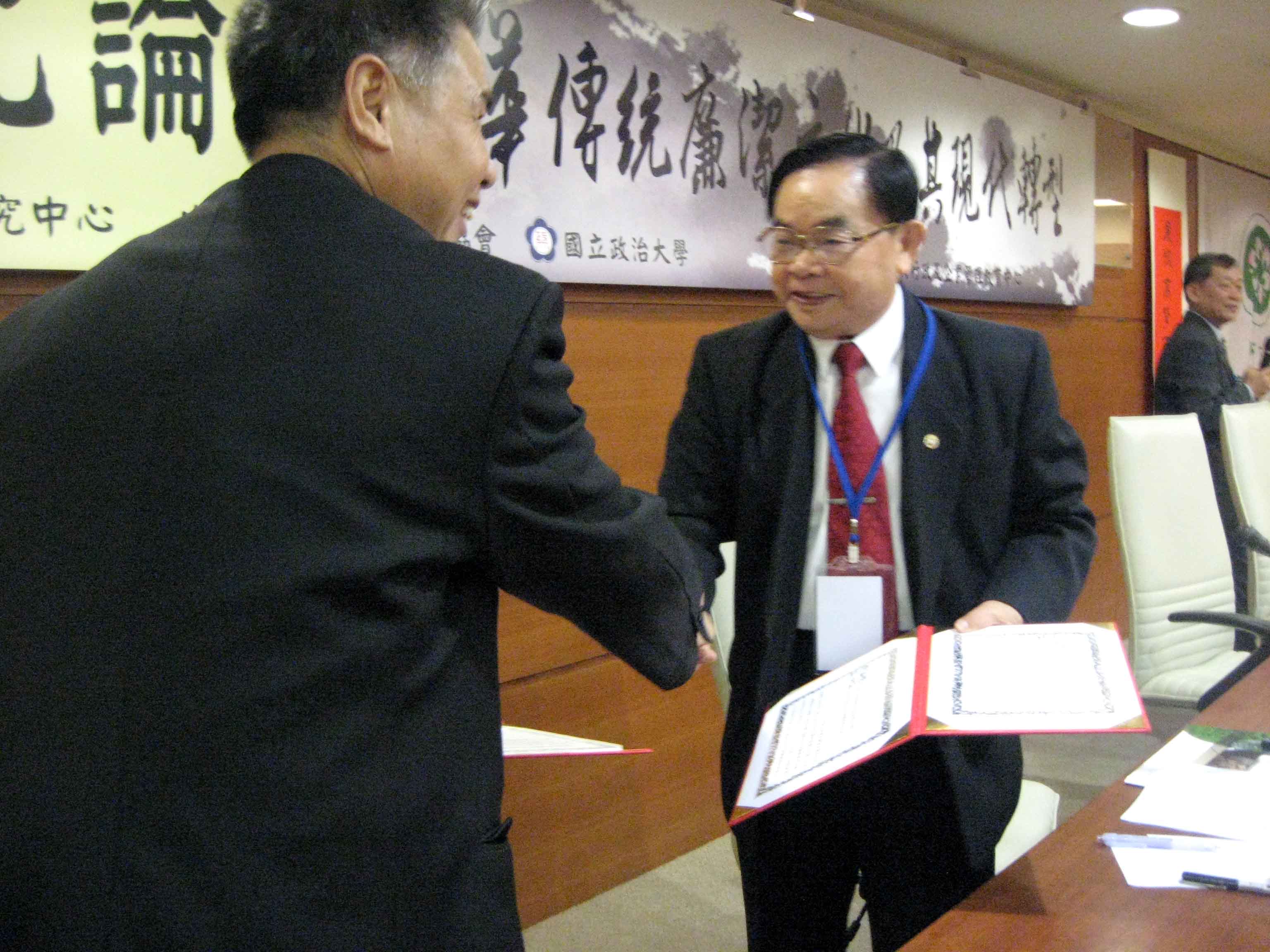 签署两会文化交流意向书后汪太理教授与欧阳彪副会长（右）握手